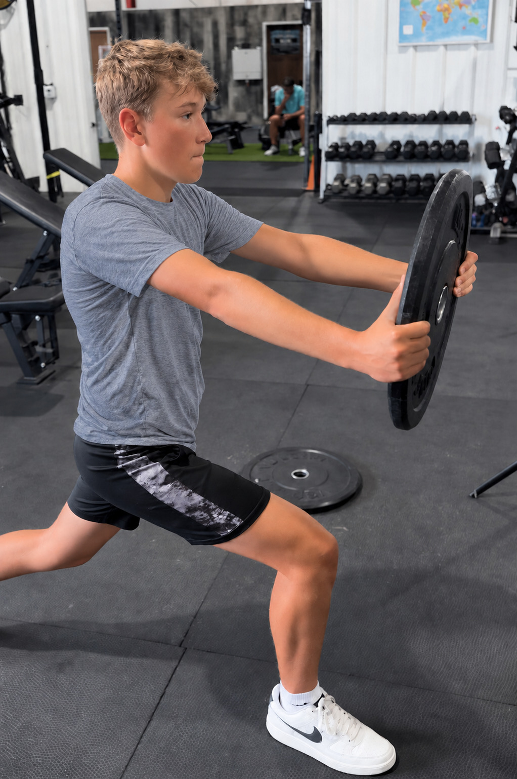 A young golfer training control and strength in a split stance
