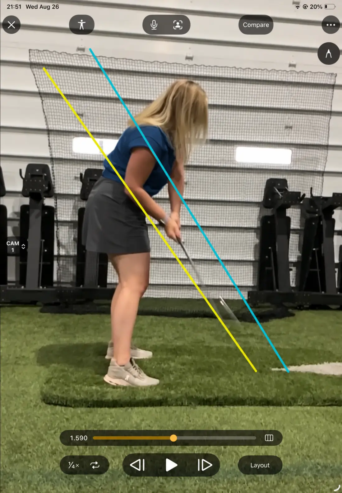 A golfer approaching impact during video swing analysis with alignment lines